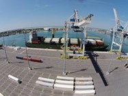 A large container ship is securely docked at a bustling port, ready for loading and unloading operations.